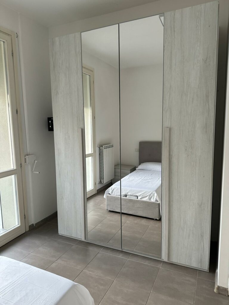 Camera luminosa dell'appartamento La Siesta con armadi a specchio e arredamento moderno